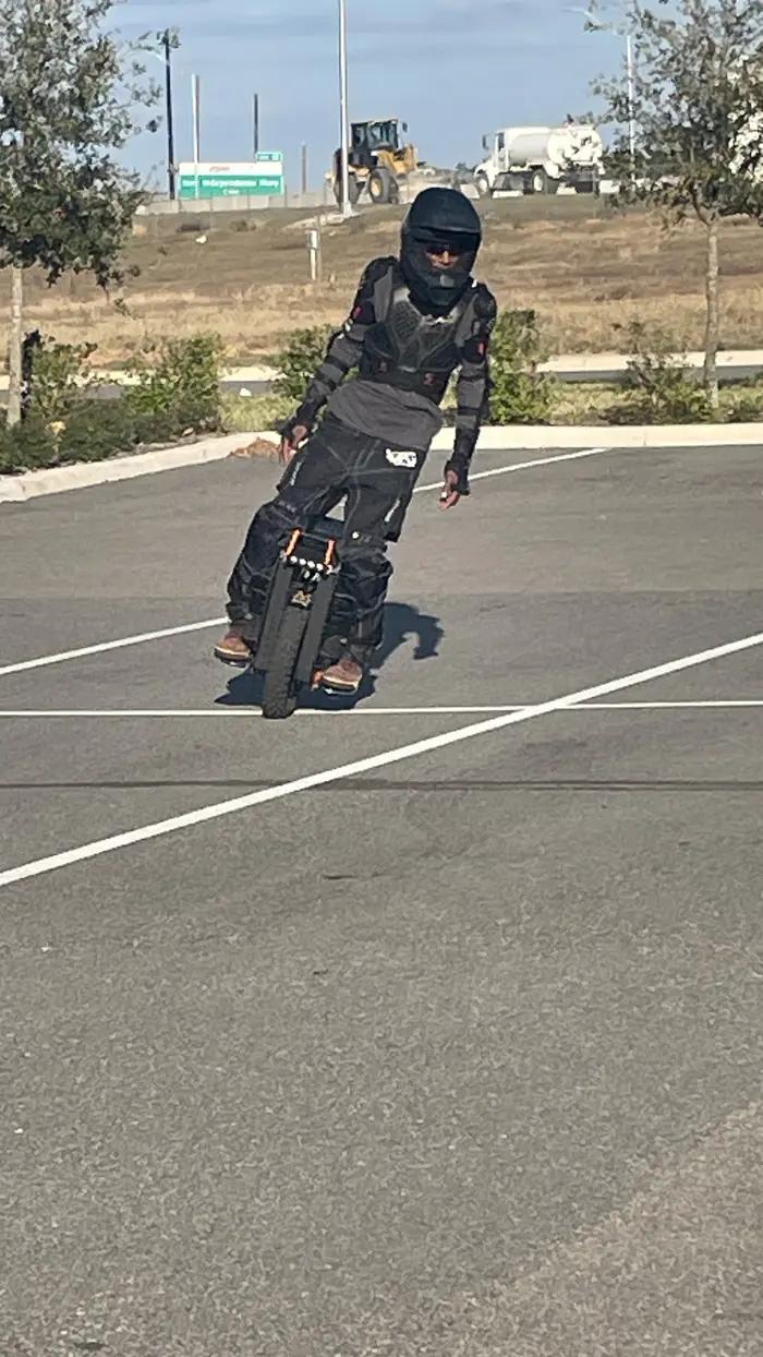 Phillip riding across the lot in full gear